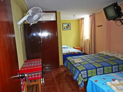 a hotel room with two beds and a fan at Hostal Geminis in Ica