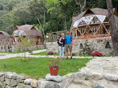 a man and a woman standing in front of a house at Salkantay Majestic Domes Eco Lodge in Sahuayacu