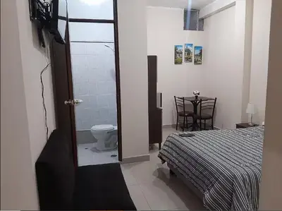 a bedroom with a bed and a bathroom with a toilet at Habitación privada cerca a la plaza Constitución en un 1er piso in Huancayo