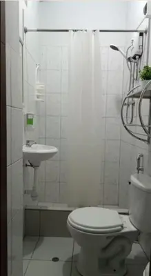 a white bathroom with a toilet and a sink at Habitación privada cerca a la plaza Constitución en un 1er piso in Huancayo