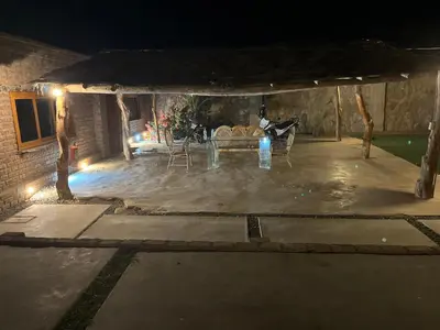 a patio at night with a table and chairs at Babylon Mansion in Nazca