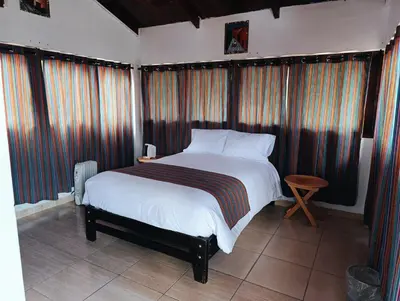 a bedroom with a large bed and some windows at Samana House Yanahuara Valle Sagrado in Urubamba