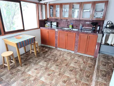 a kitchen with orange cabinets and a table and stool at Samana House Yanahuara Valle Sagrado in Urubamba