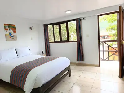 a bedroom with a bed and a large window at Samana House Yanahuara Valle Sagrado in Urubamba