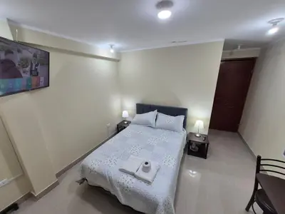 a bedroom with a bed with a towel on it at Habitación privada con vista a la calle cerca a la plaza Constitución in Huancayo