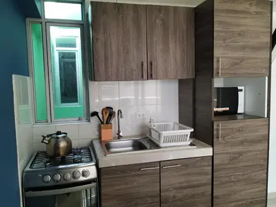 a small kitchen with a sink and a stove at La Casa de Justi in Huancayo