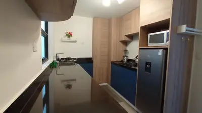 a small kitchen with a blue refrigerator and a microwave at La Casa de Justi in Huancayo