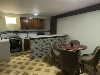 a kitchen with a table and chairs and a counter at Suites Tintaya in Cusco