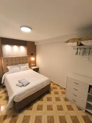 a bedroom with a bed and a dresser in it at Suites Tintaya in Cusco
