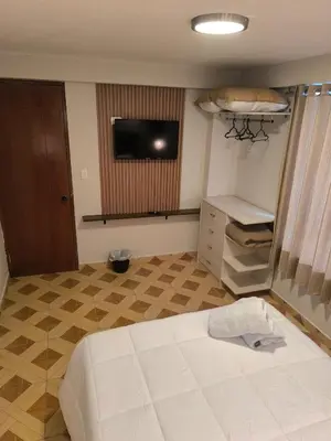 a bedroom with a bed and a flat screen tv at Suites Tintaya in Cusco