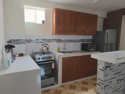 a kitchen with wooden cabinets and a stove top oven at Suites Tintaya in Cusco