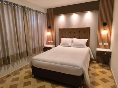 a bedroom with a large bed with two night stands at Suites Tintaya in Cusco