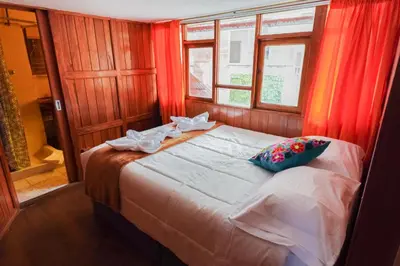 a bedroom with a large bed with red curtains at HISTORIC CENTRAL Apartment in Cusco