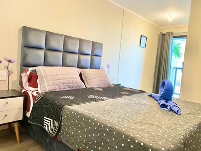 a bedroom with a large bed with a large headboard at Departamento exclusivo con vista a la ciudad in Lima