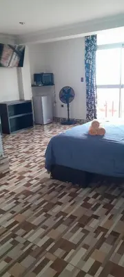 a bedroom with a bed and a wooden floor at Hostal los Faroles in Barranca