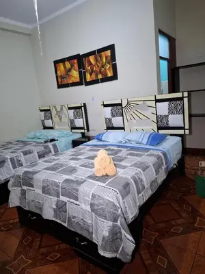 two beds in a room with at Hostal los Faroles in Barranca