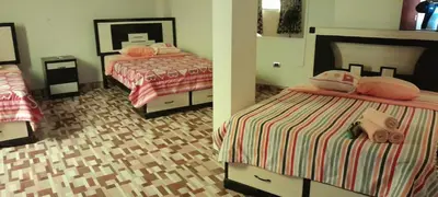 two beds in a room with two bedsskirts at Hostal los Faroles in Barranca