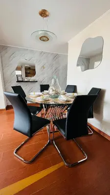 a dining room with a glass table and black chairs at A 15 minutos del aeropuerto cómodo y moderno departamento de 3 habitaciones independientes y 2 baños in Lima