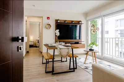 a dining room and living room with a table and chairs at Premium Miraflores Stay with Pool and Amenities in Lima