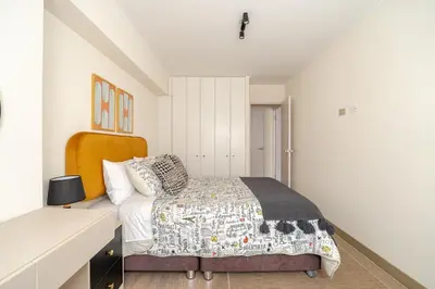 a bedroom with a bed and a white wall at Cozy apartment by Parque Kennedy, Miraflores in Lima