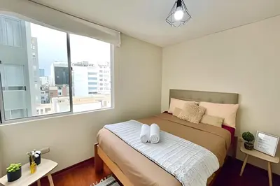 a bedroom with a bed and a large window at Cosy place retreat Miraflores 3BR in Lima