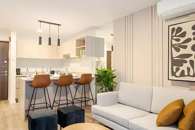 a living room with a white couch and a kitchen at Edificio Los Pinos in Lima