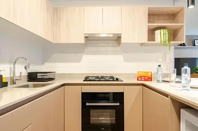 a kitchen with wooden cabinets and a stove top oven at Edificio Los Pinos in Lima