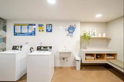 a white bathroom with a sink and a counter at Edificio Los Pinos in Lima