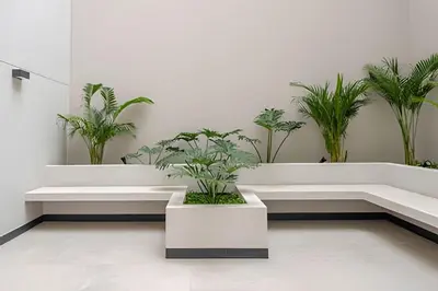 a white lobby with potted plants on the wall at Edificio Los Pinos in Lima