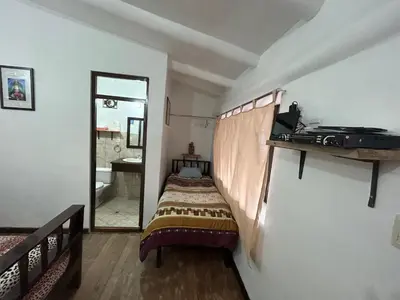 a small bedroom with a bed and a mirror at Bed and Breakfasts - Ollantaytambo by ViaHero in Ollantaytambo