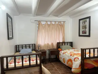 a bedroom with two beds and a window at Bed and Breakfasts - Ollantaytambo by ViaHero in Ollantaytambo
