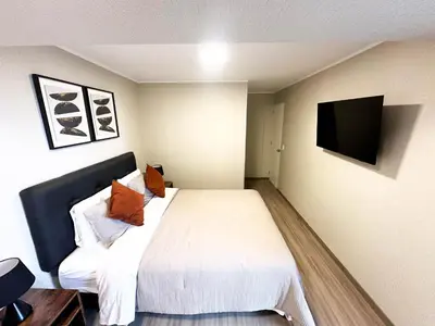 a bedroom with a bed and a tv on the wall at Hermoso departamento de estreno in Lima