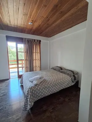 a bedroom with a bed and a wooden ceiling at Bellavista Hospedaje Vista asombrosa in Oxapampa