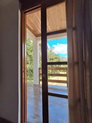 a door to a balcony with a view of a porch at Bellavista Hospedaje Vista asombrosa in Oxapampa