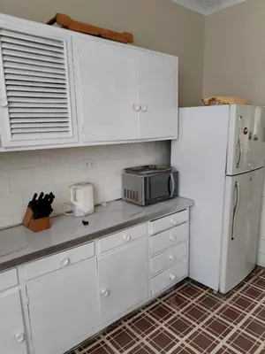 a kitchen with white cabinets and a white refrigerator at Spacious apartment - San Isidro in Lima