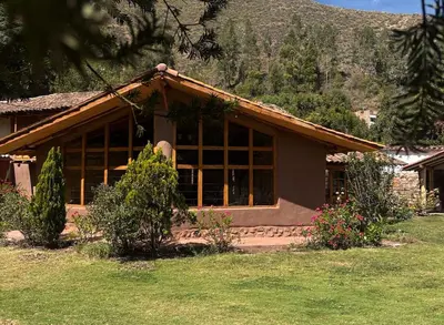 a house with large windows in a yard at Urquillos Wasi - Andean Cottage in Urubamba