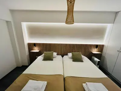 two beds in a small room with two lights at Beautiful cozy apartment in Cusco