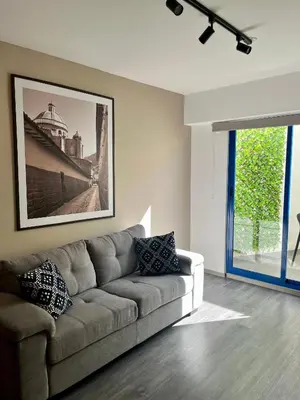 a living room with a couch and a picture of a bridge at Beautiful cozy apartment in Cusco