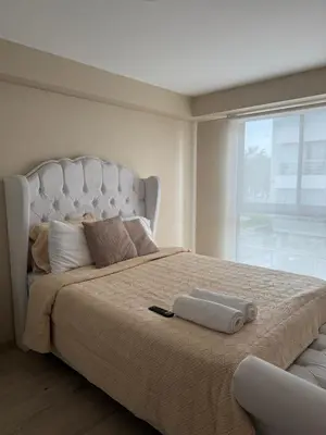 a bedroom with a large bed with a large window at Lovely apartment in Lima