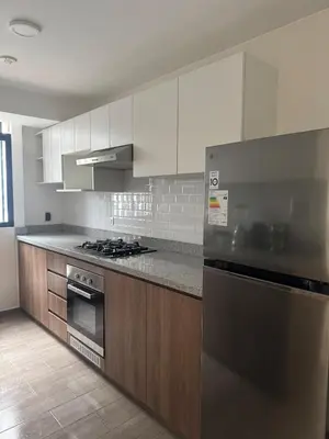 a kitchen with white cabinets and a stainless steel refrigerator at Lovely apartment in Lima