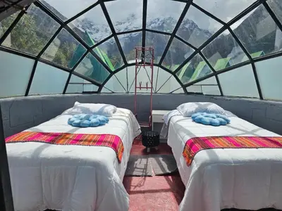 two beds in a room with a glass ceiling at Salkantay starcamp in Anta
