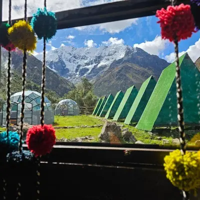 a view of a mountain from a window with flowers at Salkantay starcamp in Anta