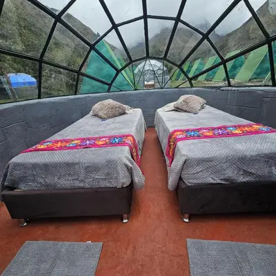two beds in a room with a glass wall at Salkantay starcamp in Anta