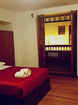 a bedroom with a red bed and a large mirror at Imperial Cusco INN in Cusco