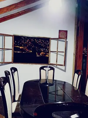 a dining room with a table and chairs with a view at Imperial Cusco INN in Cusco