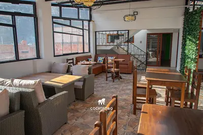 a restaurant with tables and chairs and a staircase at Cocatambo in Ollantaytambo