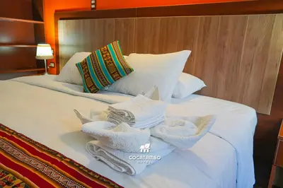 a bedroom with a bed with towels on it at Cocatambo in Ollantaytambo