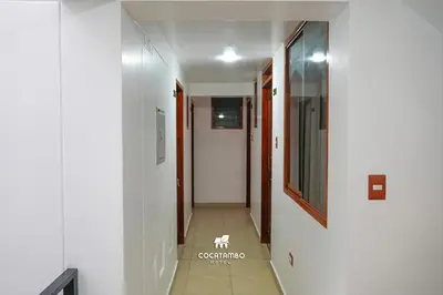 a hallway with white walls and a hallway with a dog on the floor at Cocatambo in Ollantaytambo