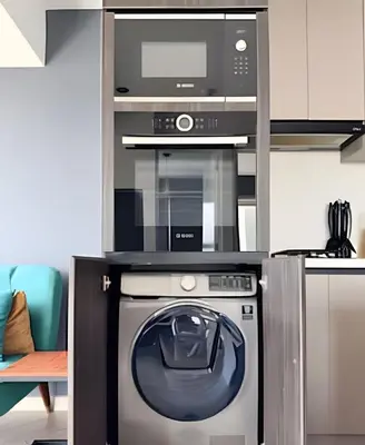 a kitchen with a microwave and a washing machine at Edificio Olavegoya in Lima