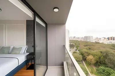 a bedroom with a bed and a balcony with a view at Edificio Parque Castilla in Lima